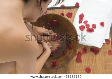 woman washing her feet with roses in an spa
