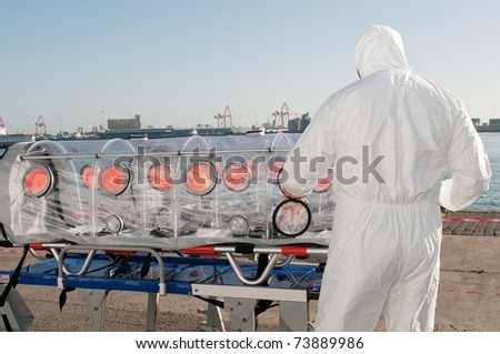 medical man with ambulance bed isolated for ebola, virus or nuclear alarm