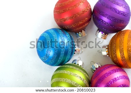 A circle of brightly colored Christmas ornaments with copy space.