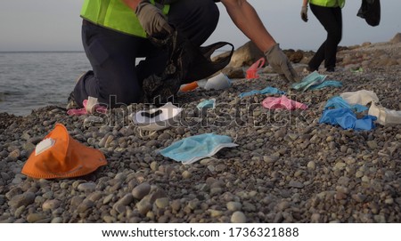 Similar – Image, Stock Photo Coronavirus garbage. Volunteers collecting used disposable medical masks and gloves near the bus stop and along the highway. The problem of environmental pollution during a pandemic COVID-19