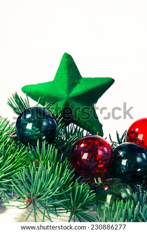 christmas balls and green star over green pine branches