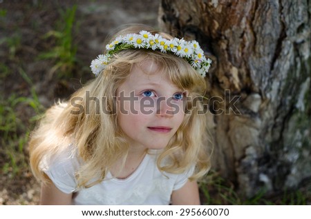 adorable smiling little blond girl with daisy flower headband