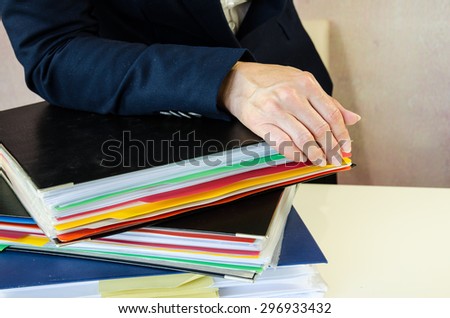 female hand typing into tablet behind working desk