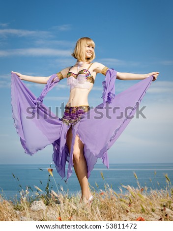 Slim girl in costume for oriental dance on seashore