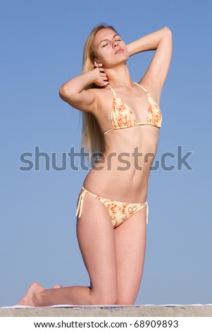 Girl at the sea. Attractive young woman in bikini on background of clear sky