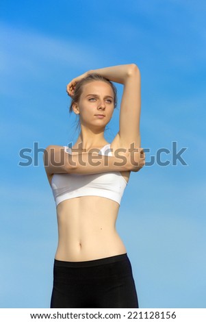 Slim girl on open air. Attractive young woman in sportswear on background of sky