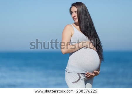Pregnant woman at the sea. Expectant mother on the last stage of pregnancy on background of sea