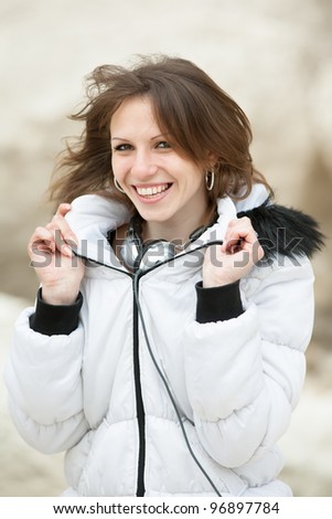 Young woman with headphones on open air. Attractive dark-haired female with headphones looking at camera smiling