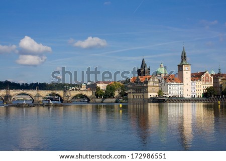 Medieval Prague architecture on the river shore on sunny day with some clouds.