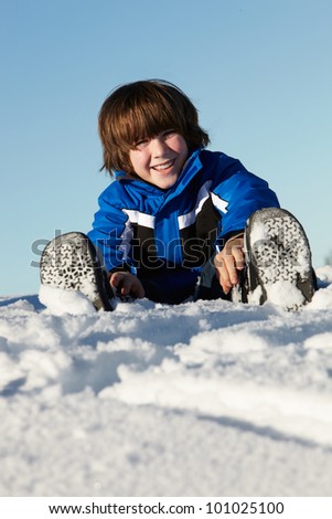 Young Boy Playing In Snow On Holiday In Mountains