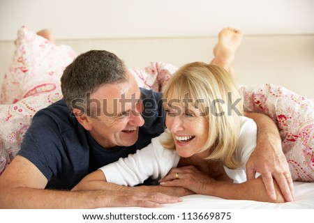 Senior Couple Relaxing Together In Bed