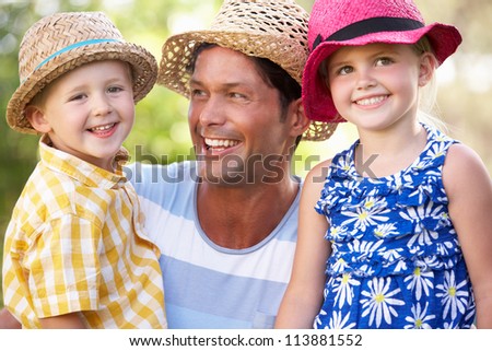 Father And Children Relaxing In Summer Garden