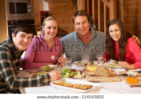 Teenage Family Enjoying Meal In Alpine Chalet Together