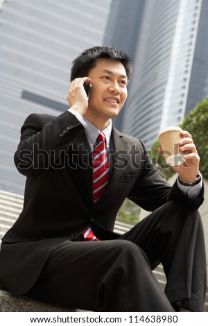 Chinese Businessman Talking On Mobile Phone With Takeaway Coffee