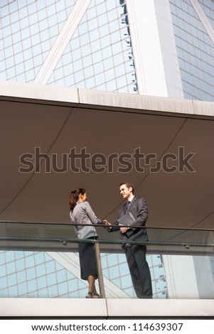 Two Business Colleagues Shaking Hands Outside Office Building