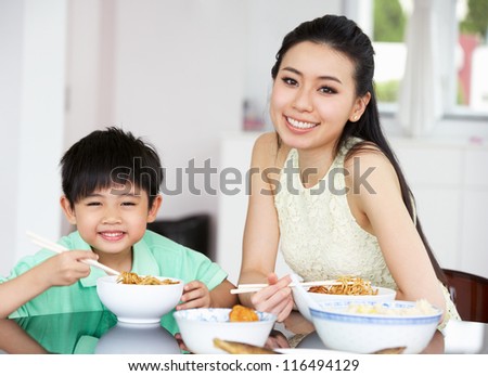 Chinese Mother And Son Sitting At Home Eating A Meal