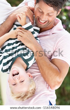Father Holding Son Upside Down Outdoors