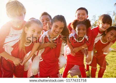 Kids in elementary school sports team piggybacking outdoors Foto stock © 