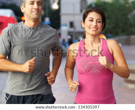 Male And Female Runners On Urban Street