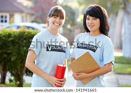 Portrait Of Two Female Charity Volunteers On Street