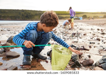 Children With Pet Dog Looking In Rockpools On Winter Beach Vacation Stock foto © 