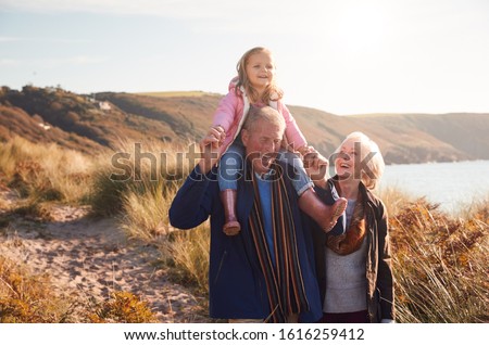 Similar – Foto Bild Großvater und Enkelin gehen am Strand und halten sich an den Händen