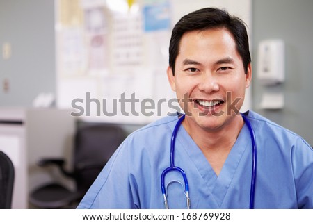 Portrait Of Doctor Working At Nurses Station