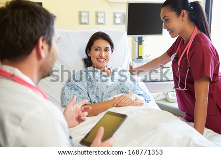 Medical Team Meeting With Woman In Hospital Room