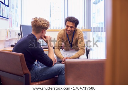 Male College Student Meeting With Campus Counselor Discussing Mental Health Issues Foto d'archivio © 