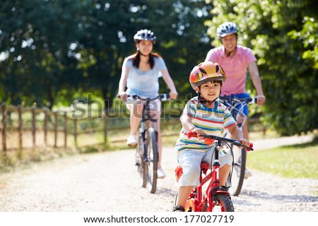 Asian Family On Cycle Ride In Countryside