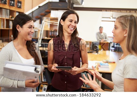 Three Female Architects Chatting In Modern Office Together