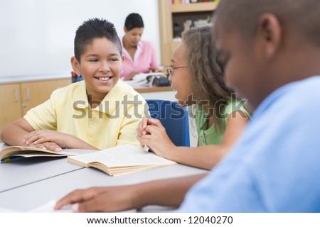 Group of pupils reading books whilst seated at desk