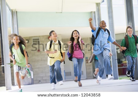 Elementary school pupils running outside together
