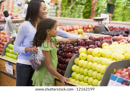 Mother and daughter in supermarket produce section
