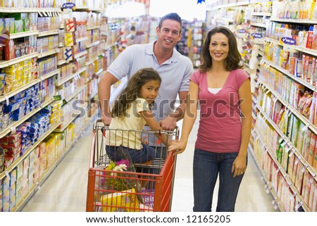 Young family grocery shopping in supermarket