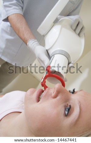 Dentist in exam room with woman in chair