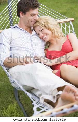 Couple relaxing in hammock smiling
