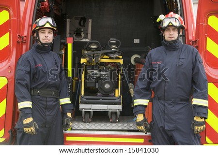 Firefighters standing by the equipment in a small fire engine