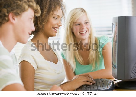 Teenagers Sitting Around A Computer