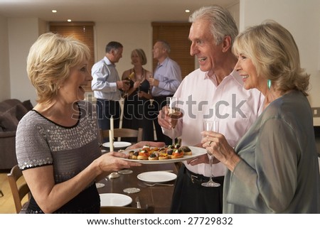 Woman Serving Hors D\'oeuvres To Her Guests At A Dinner Party