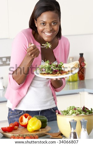 Woman Eating Meal In Kitchen