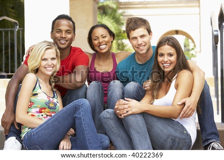 Group Of Friends Sitting On Steps Of Building