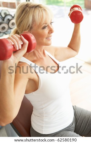 Senior Woman Working With Weights In Gym