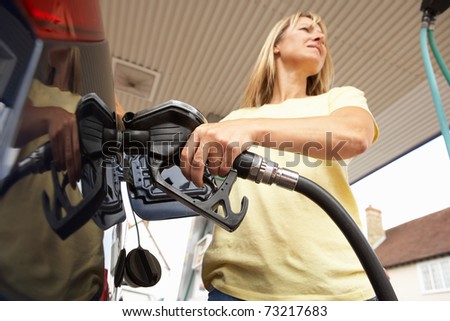 Female Motorist Filling Car With Diesel At Petrol Station