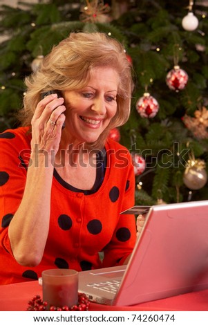 Senior Woman Shopping Online For Christmas Gifts On Phone