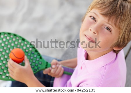 Young boy outdoors with bat and ball