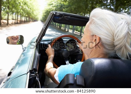 Senior woman in sports car