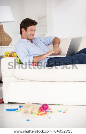 Busy father working on laptop