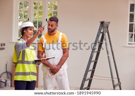 Female Surveyor With Clipboard Meeting With Decorator Working Inside Property Stock fotó © 
