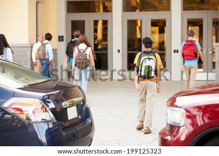 High School Students Being Dropped Off At School By Parents